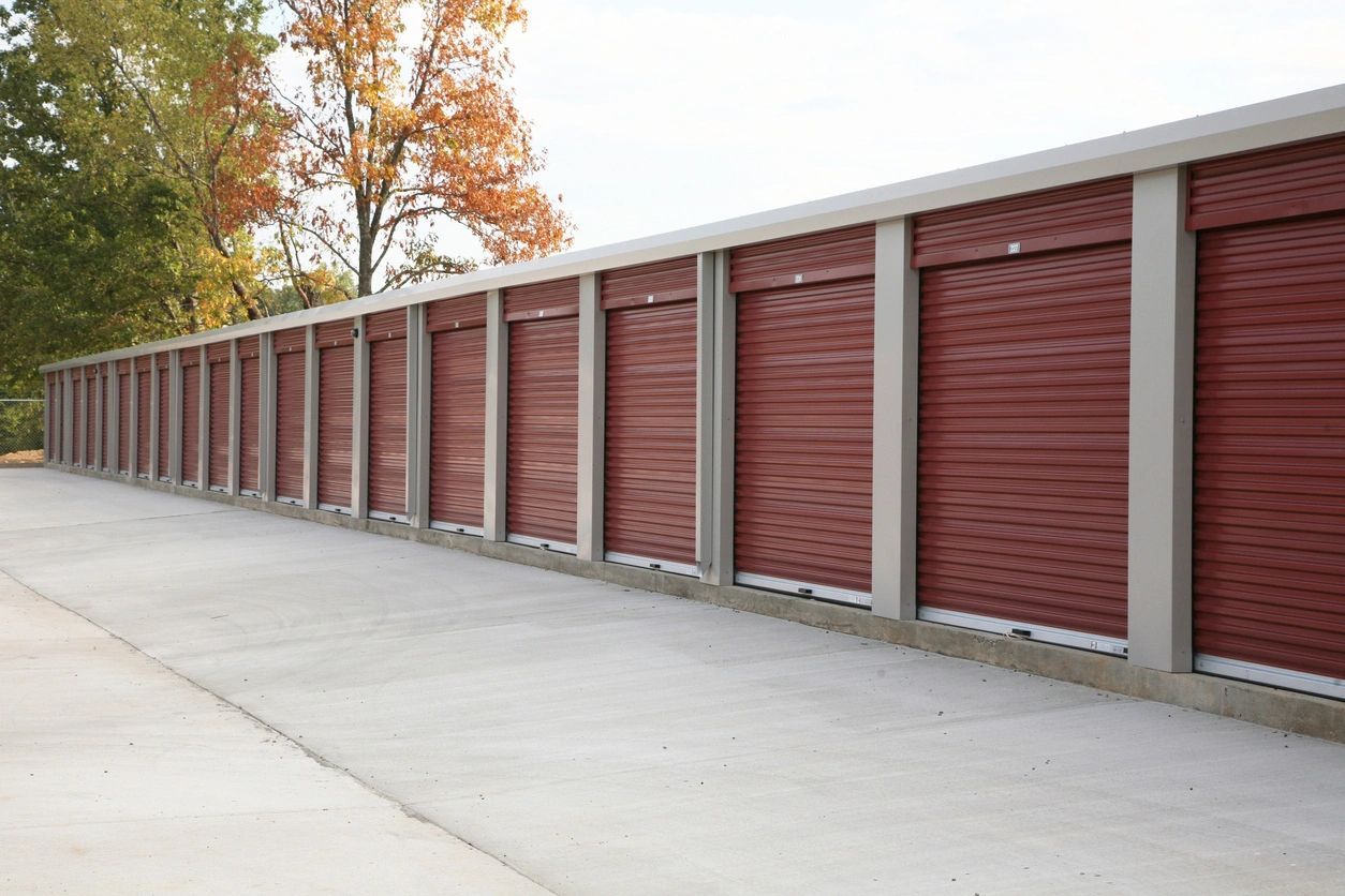 A row of red storage units on the side of a road.